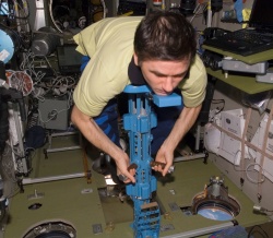 Figure 11.3. A cosmonaut uses an oscillating device to measure his body mass in weightlessness on board the ISS (Courtesy of NASA).
