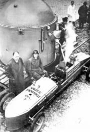 Industrialist Paul Heylandt, Max Valier and Rak 7 rocket car, April 1930. Papa Riedel in the background in white coat.
