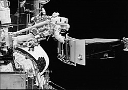 Figure 3.2. Jeff Hoffman removes the old gyro unit -- the size of a grand piano. (Courtesy of NASA)